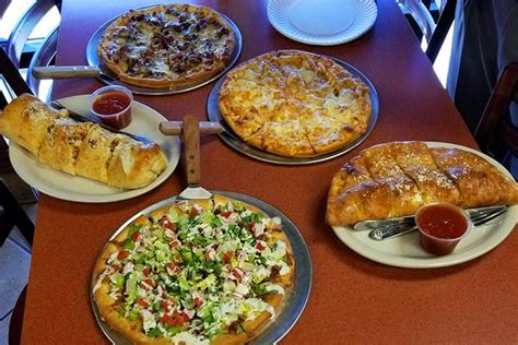 Above the crust pizza - Greek Pizza $12.95+. Sauteed spinach, feta cheese, mozzarella and olives. BBQ Chicken Pizza $12.95+. Breaded chicken, red onions and BBQ sauce. Baked Ziti Pizza $12.95+. Ziti, marinara sauce and mozzarella baked on the crust. BLT Pizza $12.95+. Baked with bacon and cheese topped with fresh lettuce and tomatoes. Veggie Pizza $12.95+.